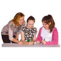 Image of mum, child transitioning and sibling or young carer around a table doing homework 