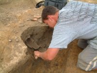 Man extracting an item from the pit