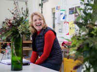 Learner smiling next to flowers