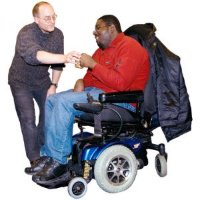 Woman in a wheelchair being assisted by a support worker in a bathroom.