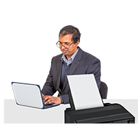 Man typing with printer nearby