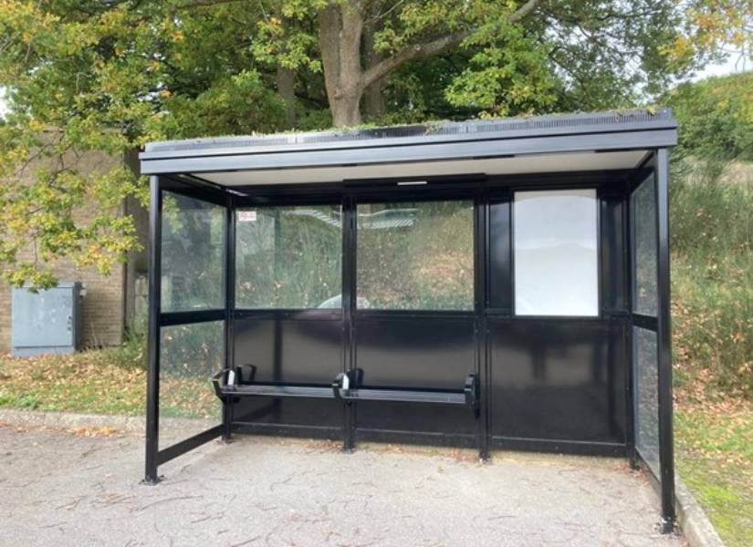 Photo of a black bus stop with seating