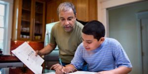 Social worker helps boy with work at the kitchen table