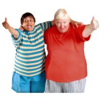 Two friends smiling and giving thumbs up while standing close together.