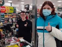Man and woman giving thumbs up to the camera in a supermarket