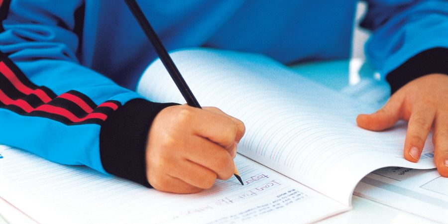 Boy writes in workbook