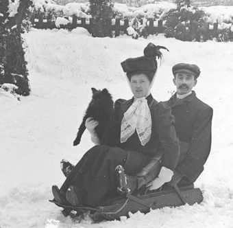 Young couple with dog enjoying the snow, c.1900. (Photographer not known). Surrey History Centre reference: 4527/1/19. 