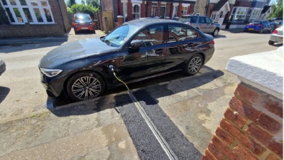 A cable gully electric vehicle charger installed with a channel in the pavement and the cable running through the channel.