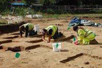 Three people at work on the dig