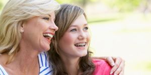 Mum with arm around daughter - both smiling