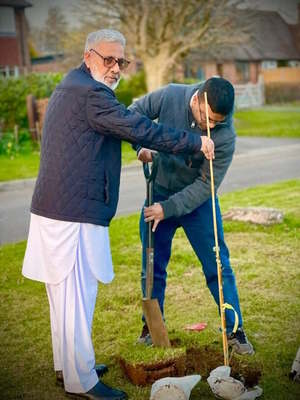 Two volunteers digging holes for planting new trees